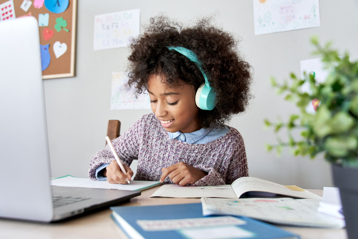 African School Kid Girl Wearing Headphones Virtual Distance Learning at Home.